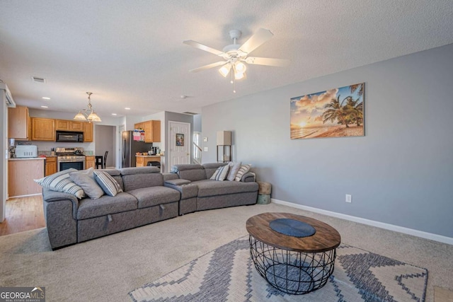 carpeted living room with ceiling fan and a textured ceiling