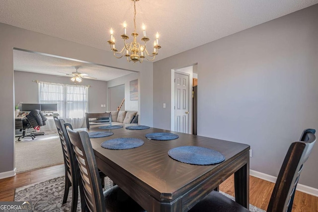 dining room featuring ceiling fan with notable chandelier, hardwood / wood-style floors, and a textured ceiling