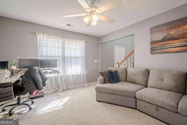 carpeted office featuring ceiling fan and a textured ceiling