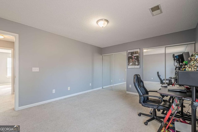 home office with a textured ceiling and carpet flooring