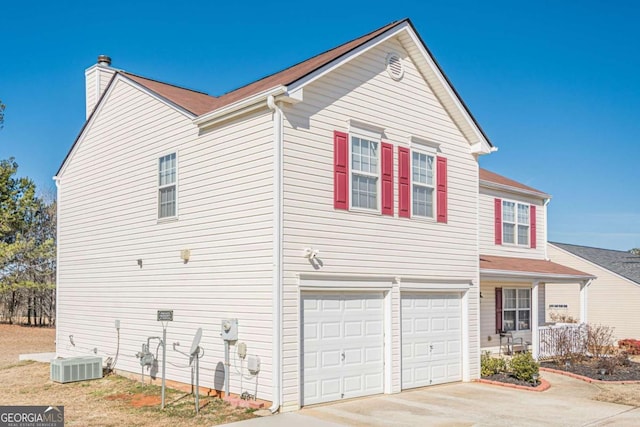 view of front of house featuring a garage and cooling unit