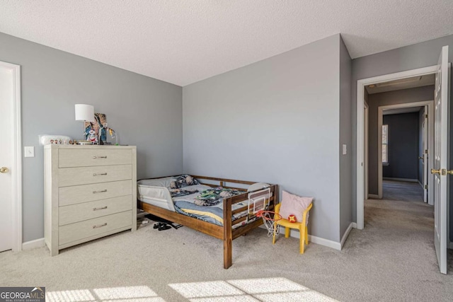 bedroom featuring light carpet and a textured ceiling