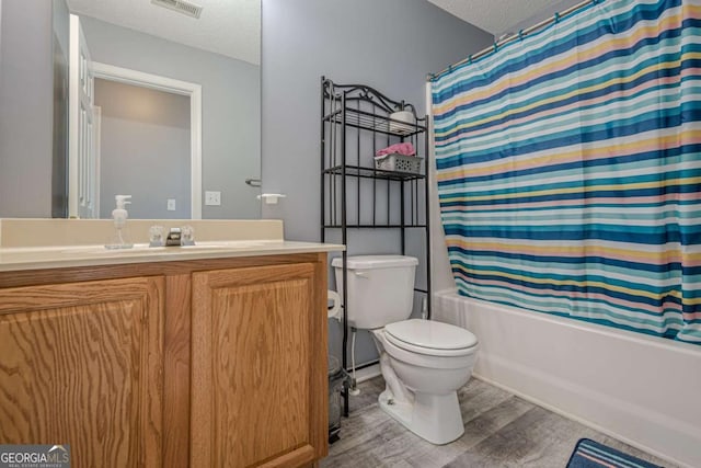 full bathroom with toilet, a textured ceiling, vanity, shower / bath combination with curtain, and hardwood / wood-style floors