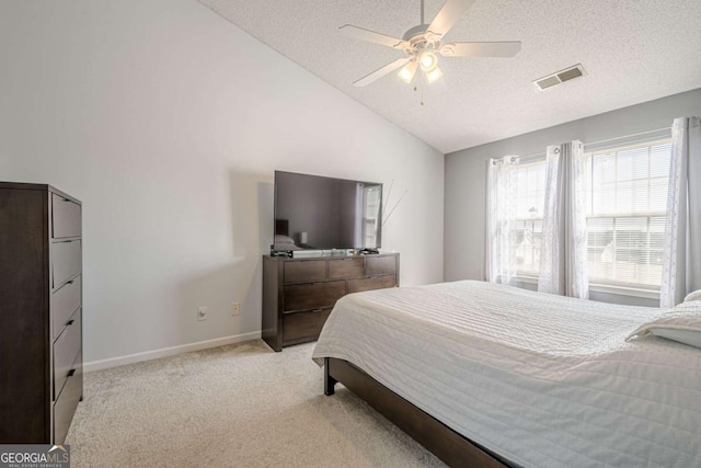 bedroom featuring ceiling fan, lofted ceiling, light carpet, and a textured ceiling