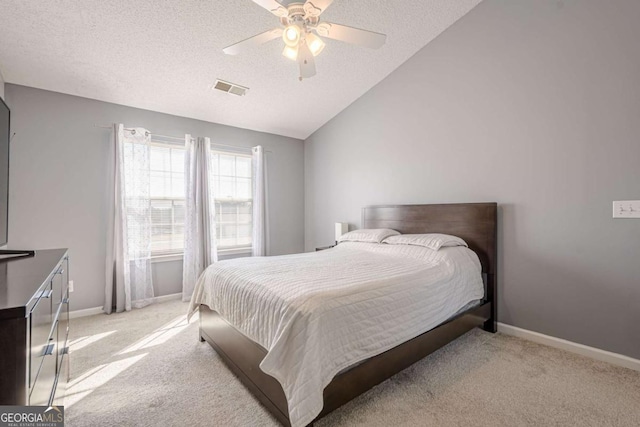 carpeted bedroom featuring ceiling fan, lofted ceiling, and a textured ceiling