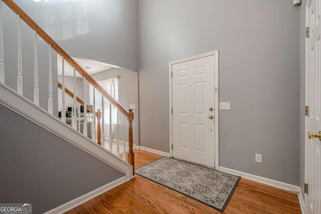 foyer entrance with a high ceiling and hardwood / wood-style floors