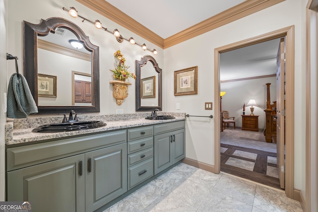 bathroom with baseboards, double vanity, a sink, and crown molding