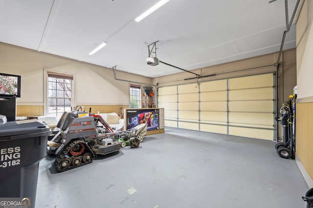 garage with a garage door opener and wainscoting
