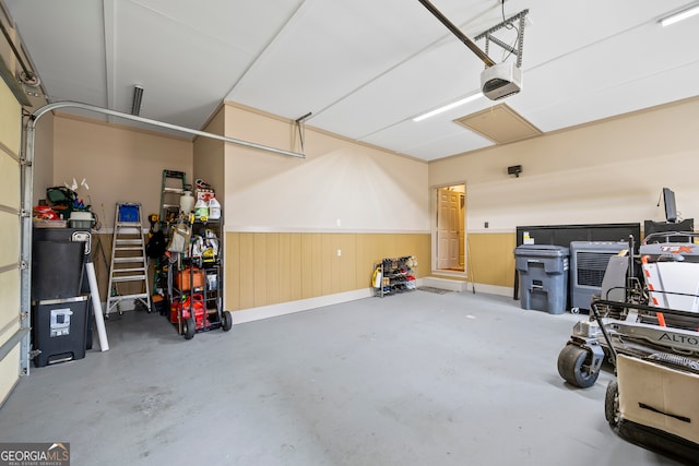 garage with a garage door opener and a wainscoted wall
