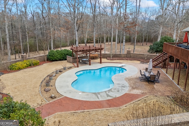 pool with a patio area, stairs, and a diving board