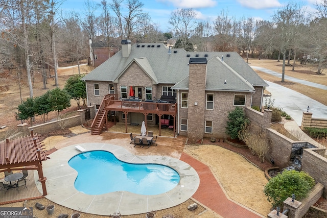 view of pool featuring a wooden deck, a diving board, and a patio