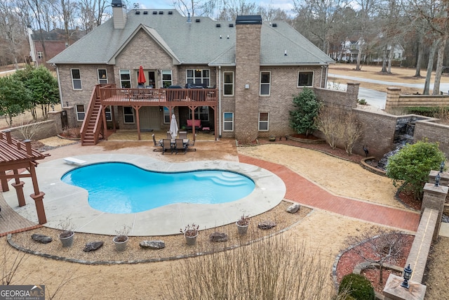 view of swimming pool featuring a deck, a patio, and a diving board