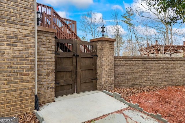 view of gate featuring fence and stairway