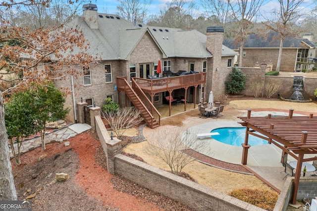 view of pool with a fenced in pool, stairway, a wooden deck, a patio area, and a pergola