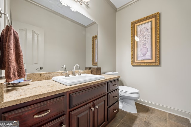 bathroom featuring baseboards, crown molding, vanity, and toilet