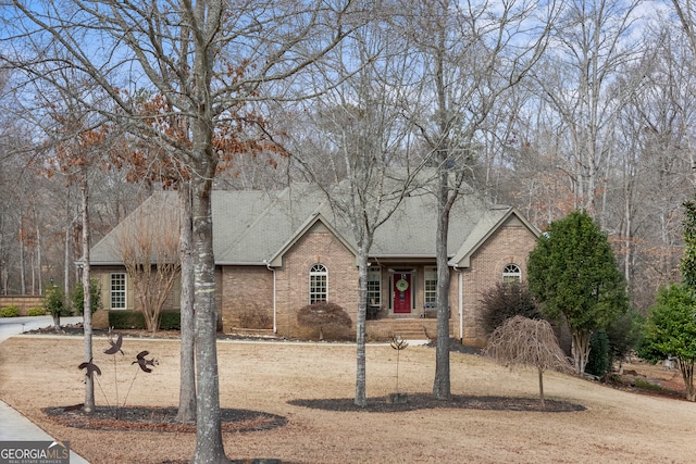 view of front of property with roof with shingles and brick siding