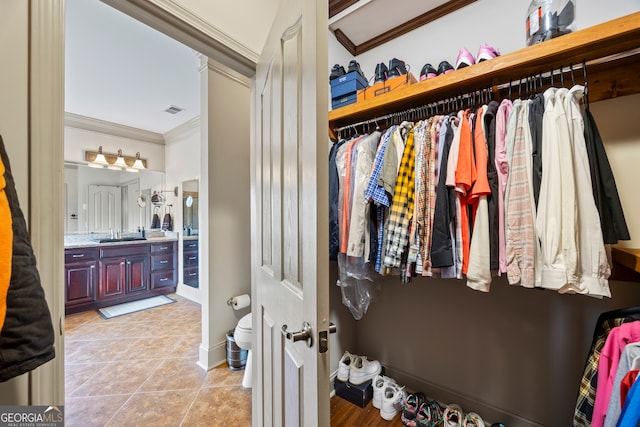 walk in closet with visible vents, a sink, and light tile patterned flooring