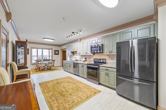 kitchen with crown molding, appliances with stainless steel finishes, sink, and rail lighting