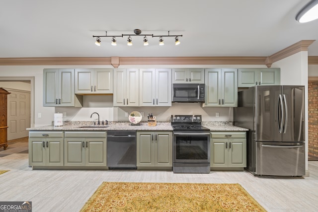 kitchen featuring light wood-style floors, ornamental molding, stainless steel appliances, and a sink