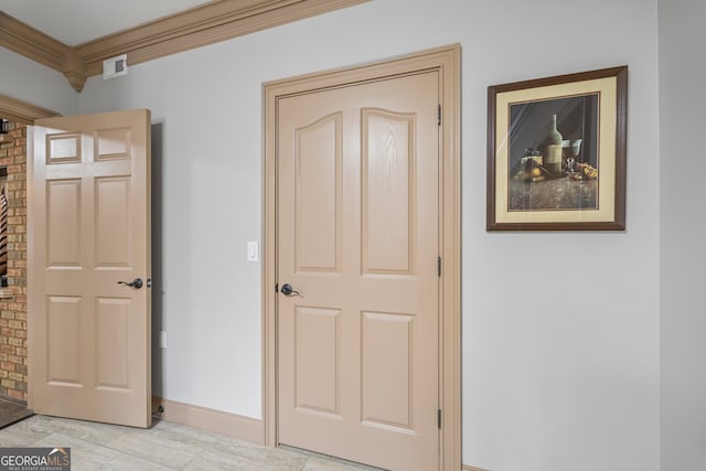 hallway featuring baseboards, visible vents, and ornamental molding