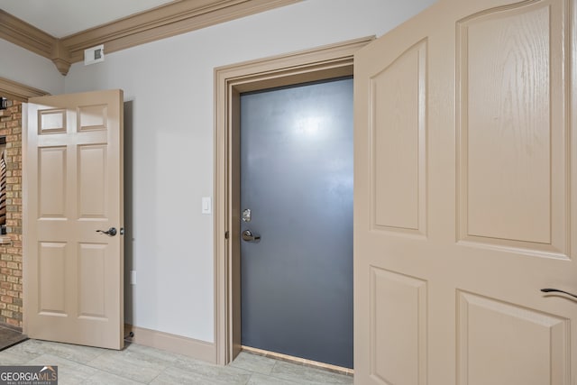 hallway with ornamental molding, visible vents, and baseboards