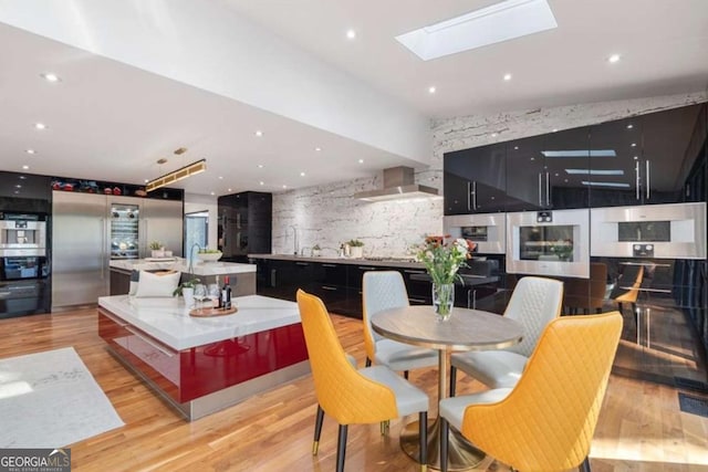dining space featuring light hardwood / wood-style flooring and a skylight