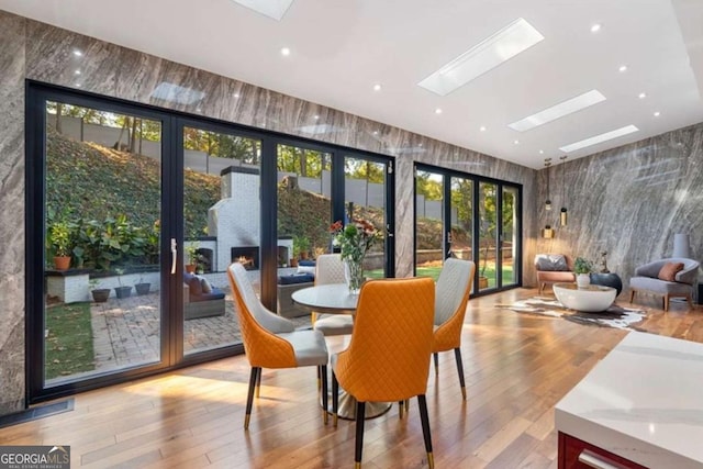 interior space with a skylight and light hardwood / wood-style floors