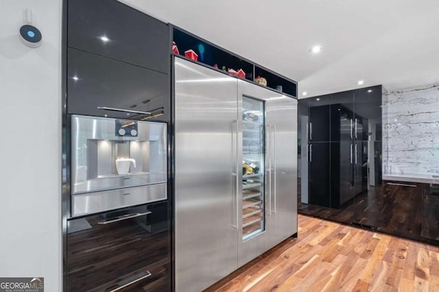 kitchen with high end fridge and wood-type flooring