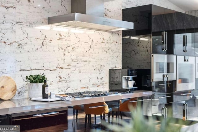 kitchen with tasteful backsplash, wall chimney range hood, and stainless steel gas stovetop