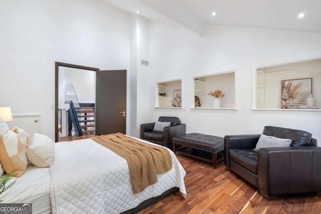 bedroom with beamed ceiling, dark hardwood / wood-style flooring, and high vaulted ceiling