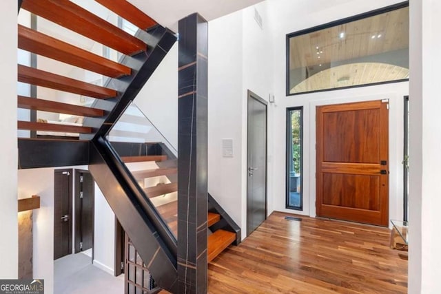 foyer entrance featuring hardwood / wood-style flooring and a high ceiling