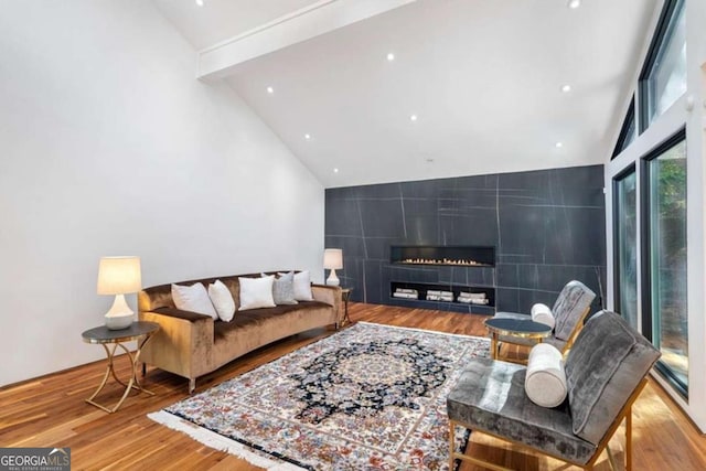 living room with beam ceiling, high vaulted ceiling, and light hardwood / wood-style floors