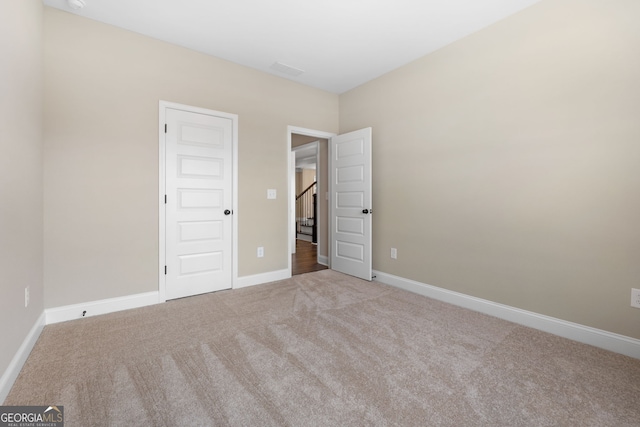 unfurnished bedroom featuring light carpet