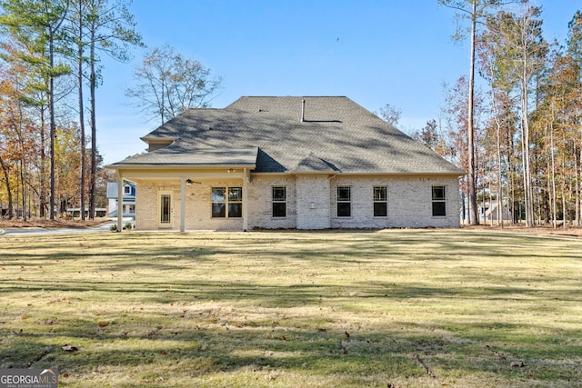 rear view of house featuring a yard