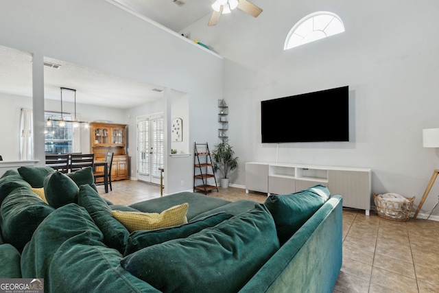 living room with light tile patterned flooring, high vaulted ceiling, and ceiling fan