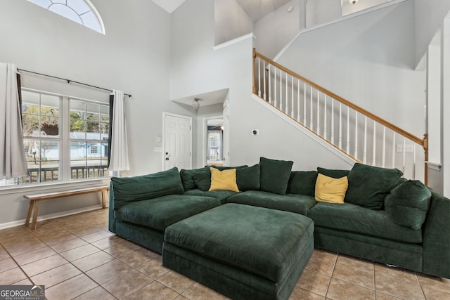 living room with a towering ceiling and light tile patterned floors