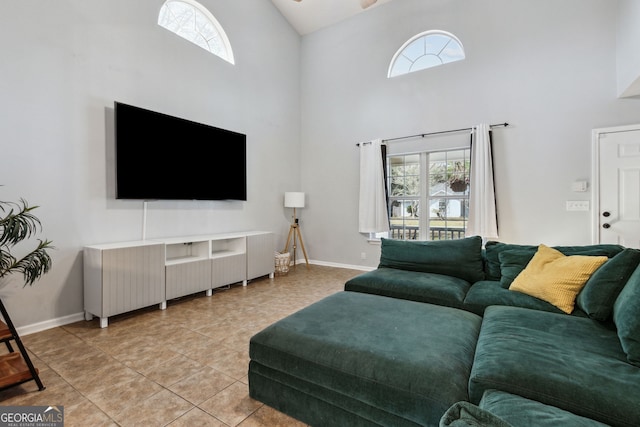 living room with light tile patterned floors and high vaulted ceiling