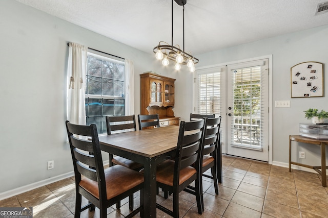 tiled dining room with a healthy amount of sunlight and french doors