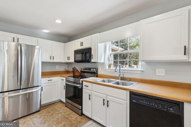 kitchen featuring white cabinetry, light tile patterned floors, sink, and black appliances