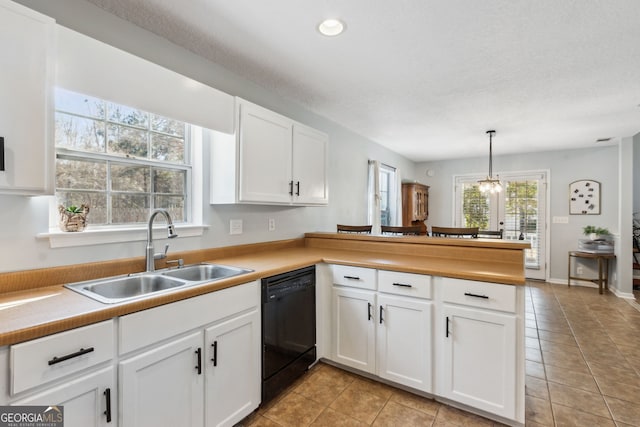 kitchen featuring pendant lighting, sink, dishwasher, white cabinets, and kitchen peninsula