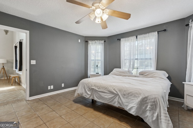 tiled bedroom featuring a textured ceiling and ceiling fan