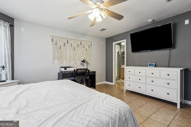 bedroom featuring a textured ceiling, ceiling fan, and light tile patterned flooring