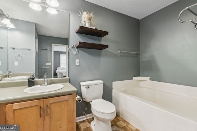 bathroom with vanity, a textured ceiling, a tub, and toilet