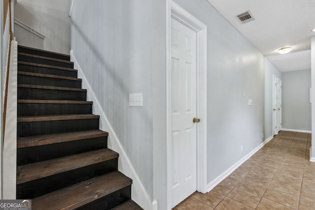 stairway with tile patterned flooring