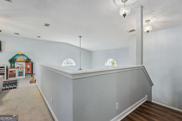 hallway featuring lofted ceiling and a textured ceiling