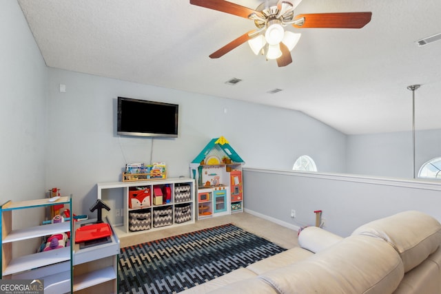 living room featuring ceiling fan, vaulted ceiling, carpet, and a textured ceiling