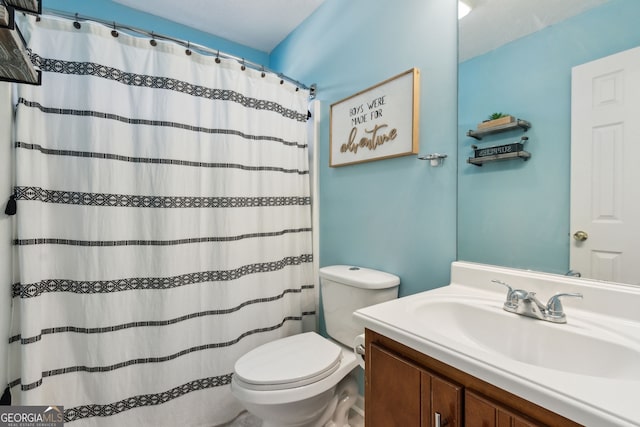 bathroom with a shower with curtain, vanity, and toilet