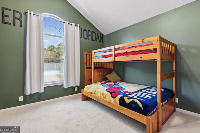 bedroom with lofted ceiling, carpet, and a textured ceiling