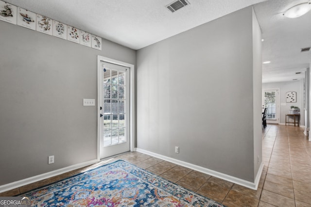 foyer entrance featuring tile patterned floors and a textured ceiling