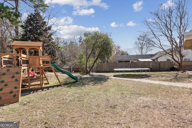 view of jungle gym with a trampoline and a lawn